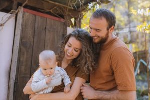 Image of a couple with baby in wife's hand